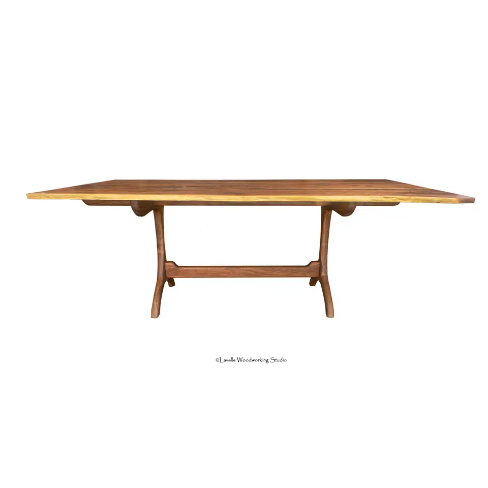 Country Dining Table with a thin walnut live edge top on a hand-shaped trestle base