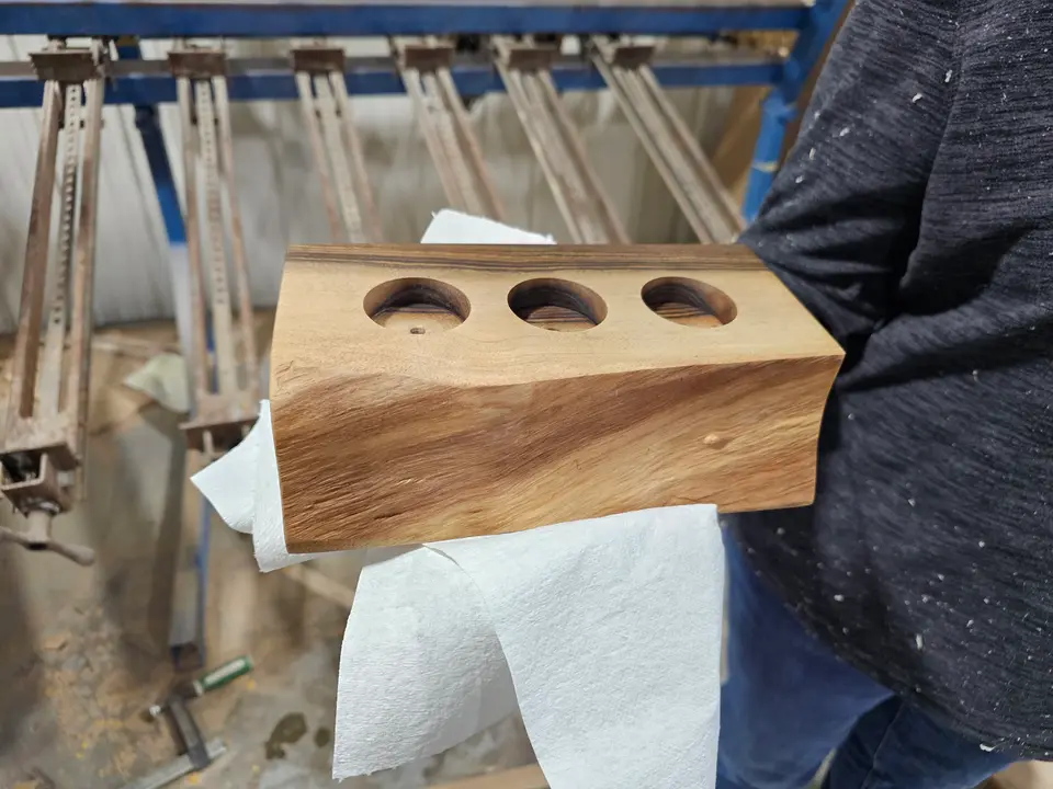 Close-up of a small wooden block project with three round holes